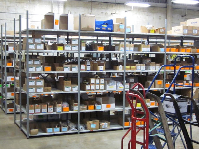 Warehouse shelves stocked with professional plumbing supplies at Huges Supply Daytona